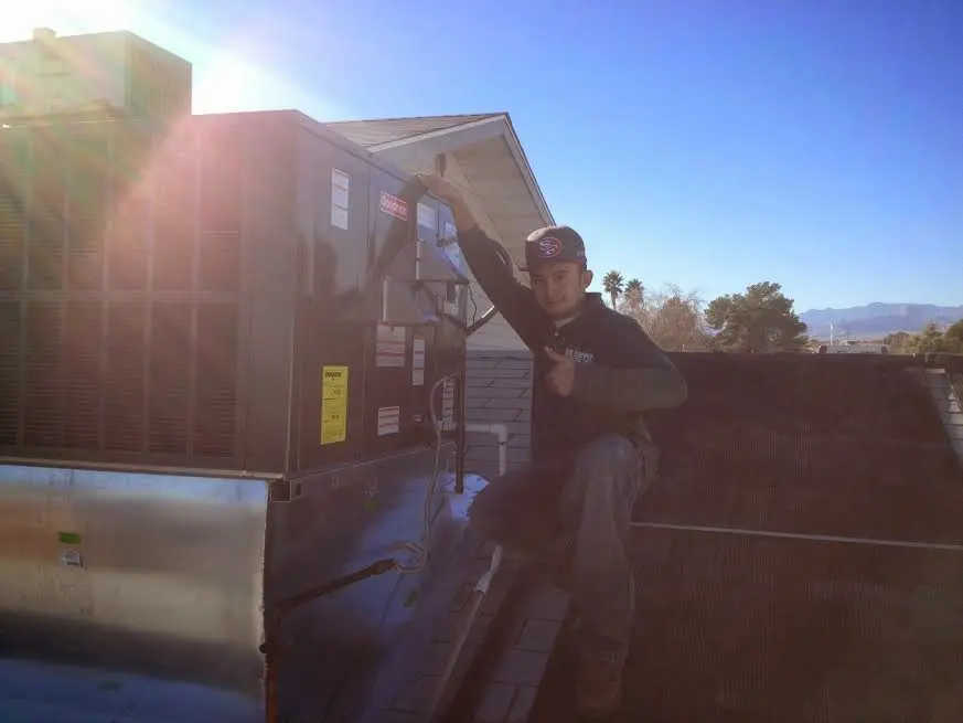 HVAC technician performing HVAC Inspection on a rooftop unit in Pinecrest